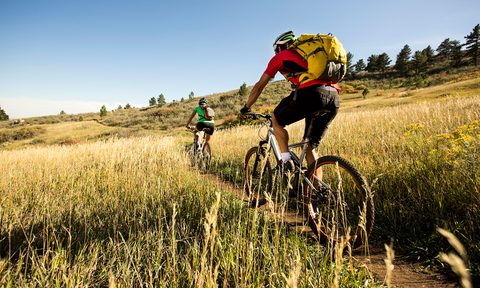 Man and woman biking on a dirt path