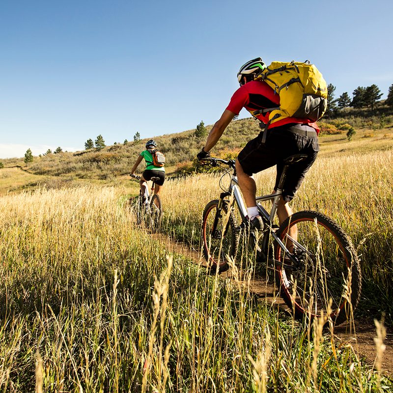 Man and woman biking on a dirt path