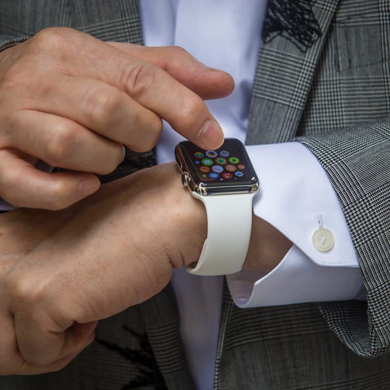 A man taps on an Apple Watch on his wrist