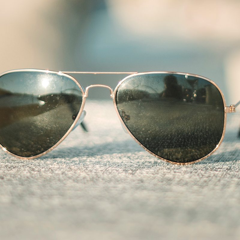 A pair of the classic aviator sunglasses with a gold metal frame. 