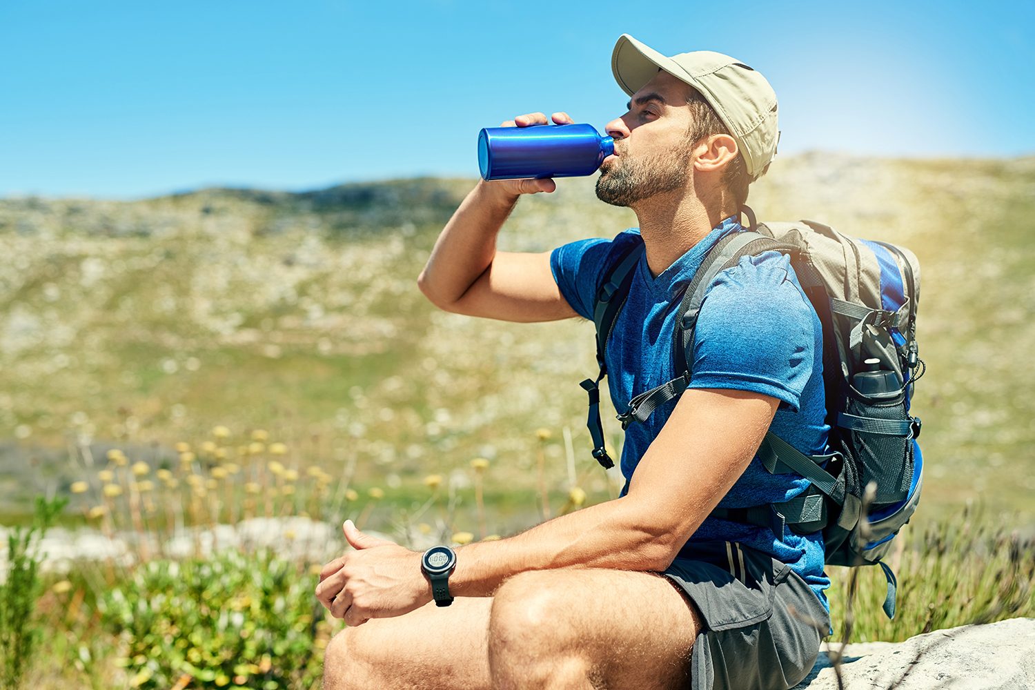 Taking a break from hiking to drink some water from an insulated water bottle