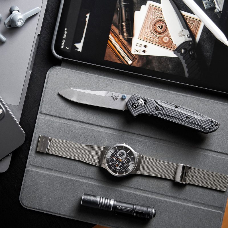 Flat-lay of a tablet with a watch, penlight, and pocketknife lying next to it