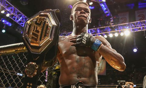 Israel Adesanya holding the UFC Middleweight Championship belt.