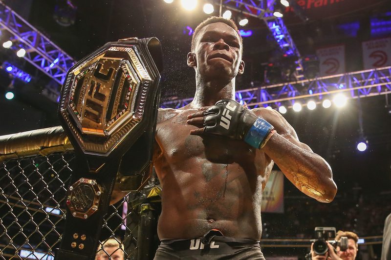 Israel Adesanya holding the UFC Middleweight Championship belt.