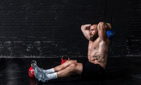 Man sitting on the ground working out.