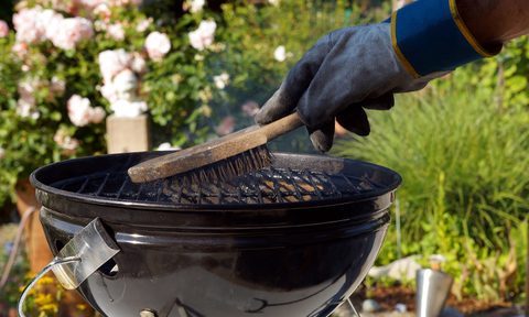 best grill cleaners cleaning a  male hand with gloves cleans stiff brush round before cooking scrubbing utensil used for dirt