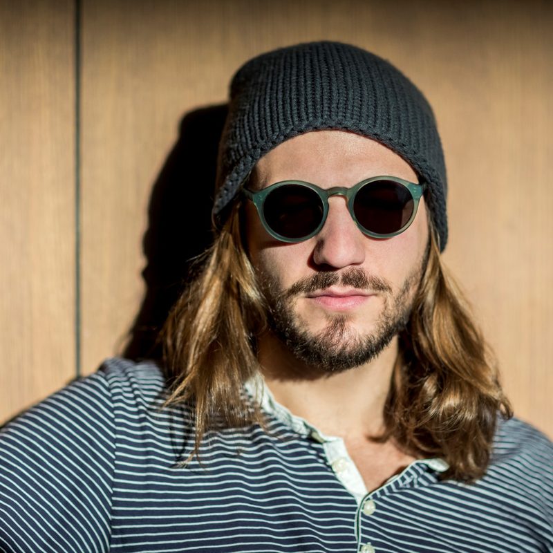 A man with long hair wearing a beanie.