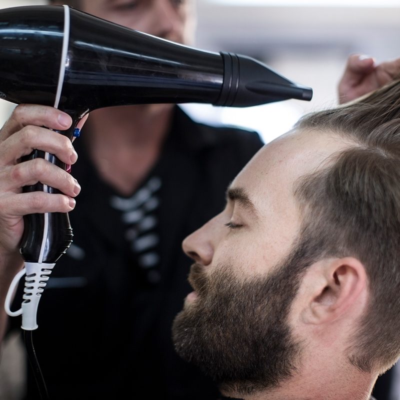 A person getting their hair styled with a blow dryer.