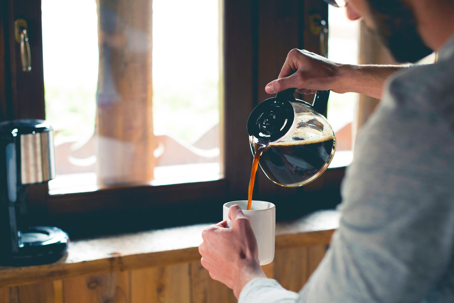 Person pouring a cup of coffee