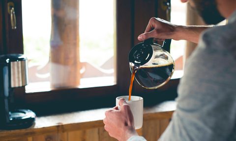 Person pouring a cup of coffee