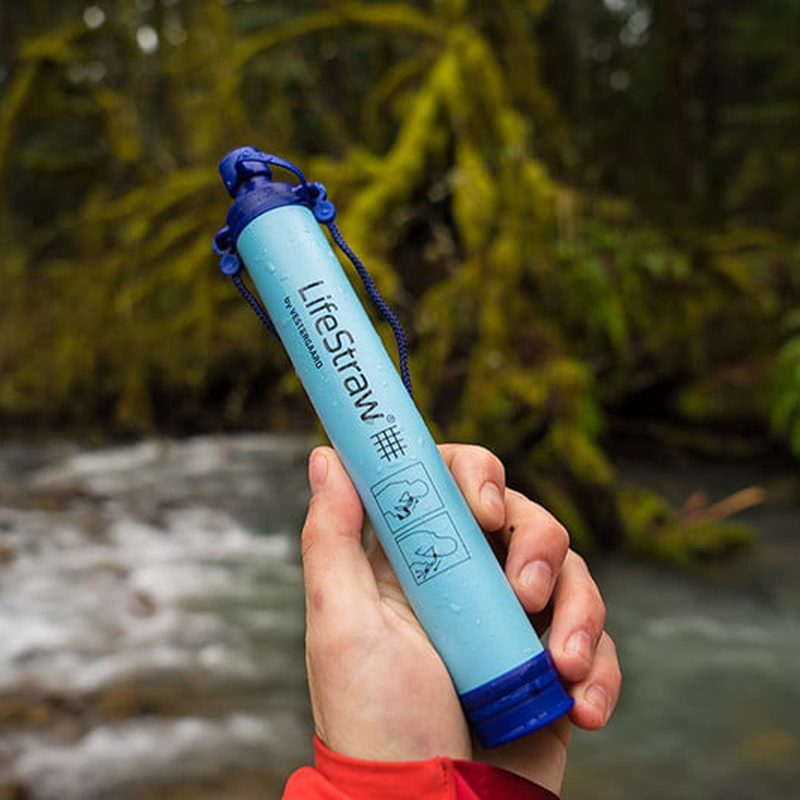 LifeStraw Personal Water Filter held by a hand outdoor.