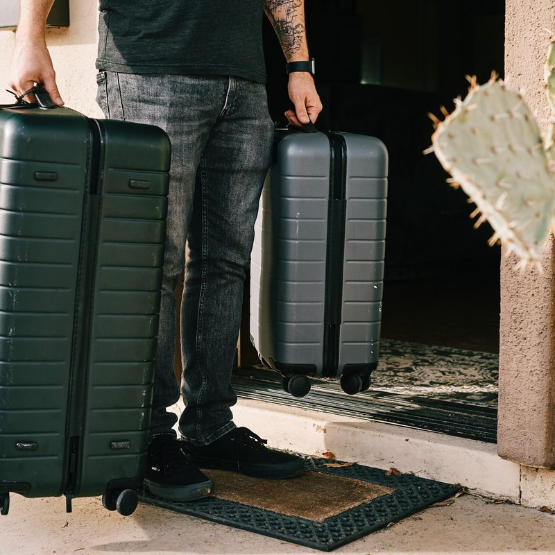 Man carrying a suitcase and carry-on suitcase