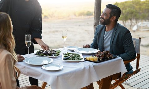 future of the post pandemic restaurant waiter serving couple at private romantic dinner in luxury cabin