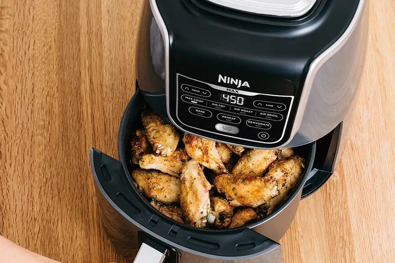Ninja Air Fryer Max XL on a wooden table.