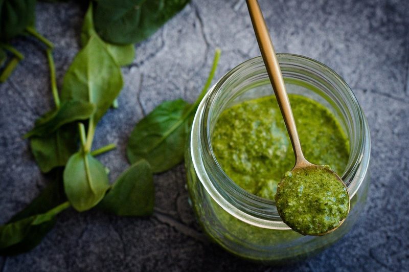 A jar and a spoonful of basil pesto