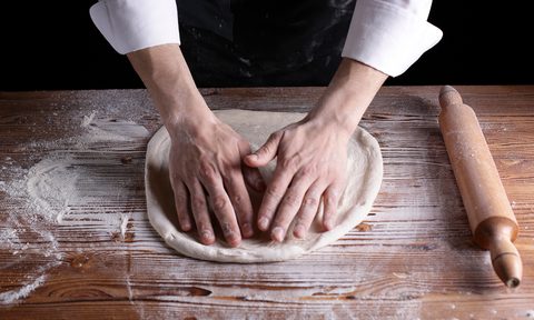 A person preparing pizza dough
