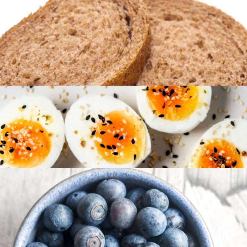 Bread, hard-boiled egg, and a bowl of blueberries.