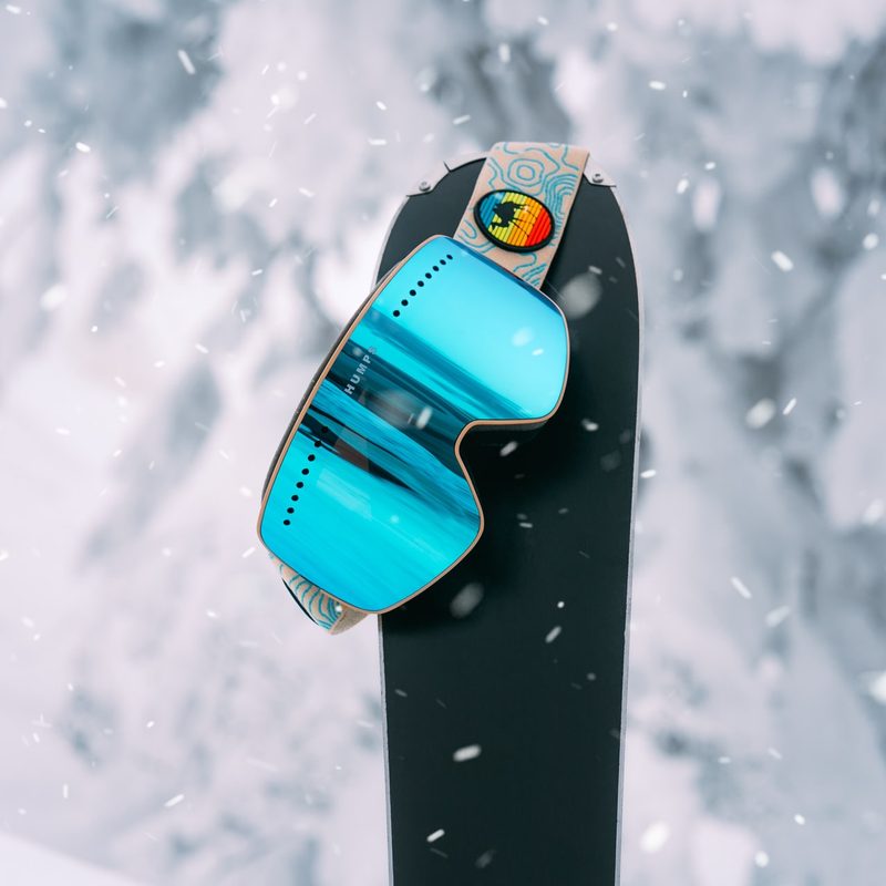 Ski goggles hanging on a snowboard