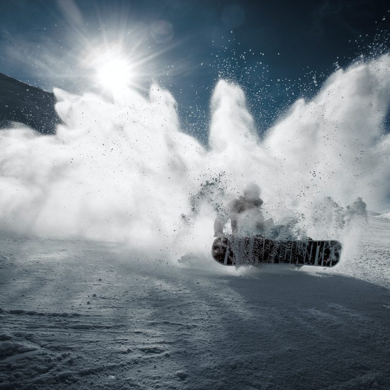 Person on a snowboard kicking up snow.