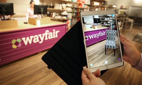 A Wayfair store with someone holding up an iPad to take an image of it.