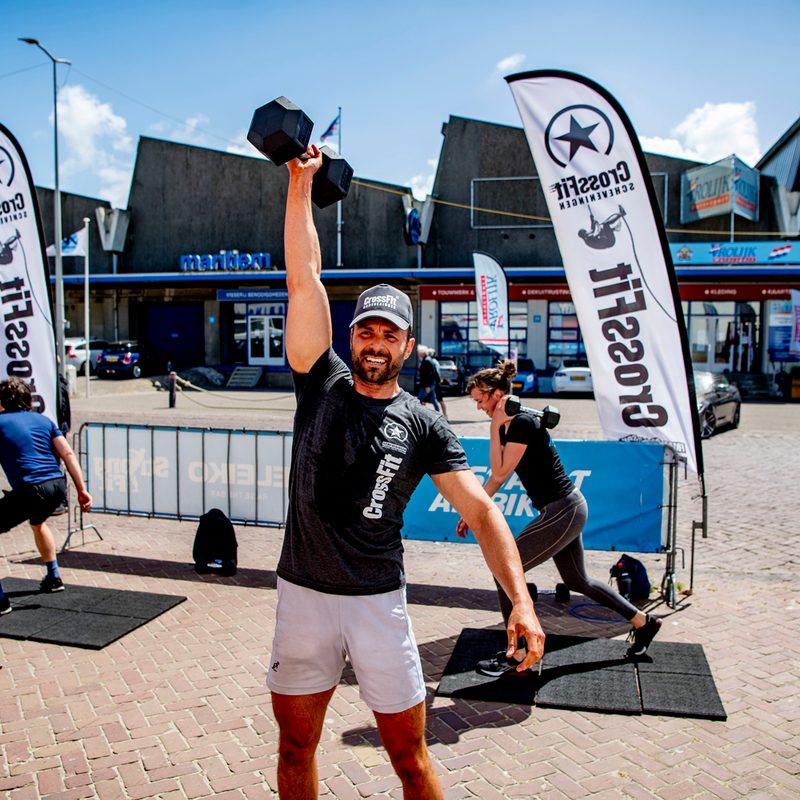 A man using a dumbbell in a CrossFit workout.