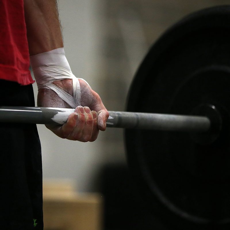 hand of a man holding a weights.