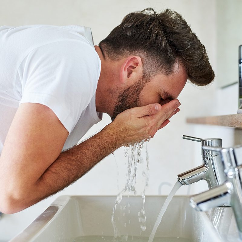 Man washing his face