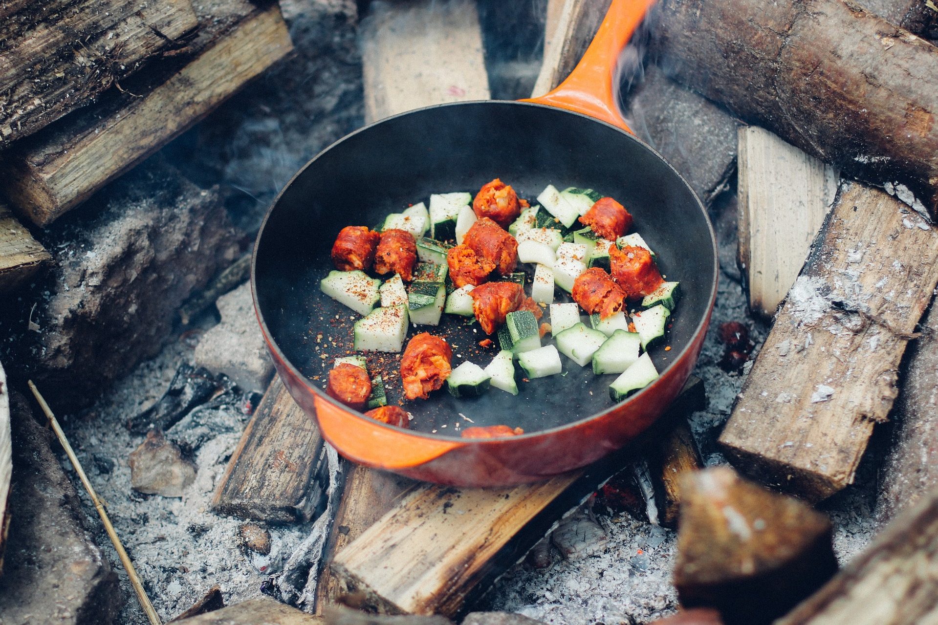 cast-iron skillet over campfire wood