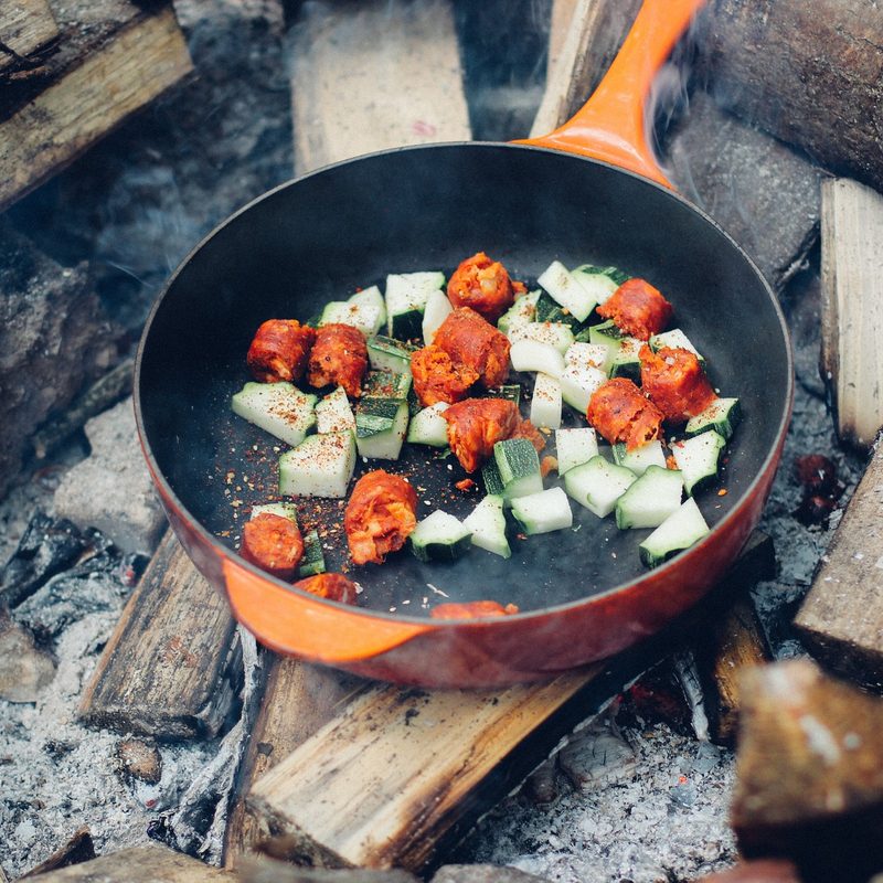 cast-iron skillet over campfire wood