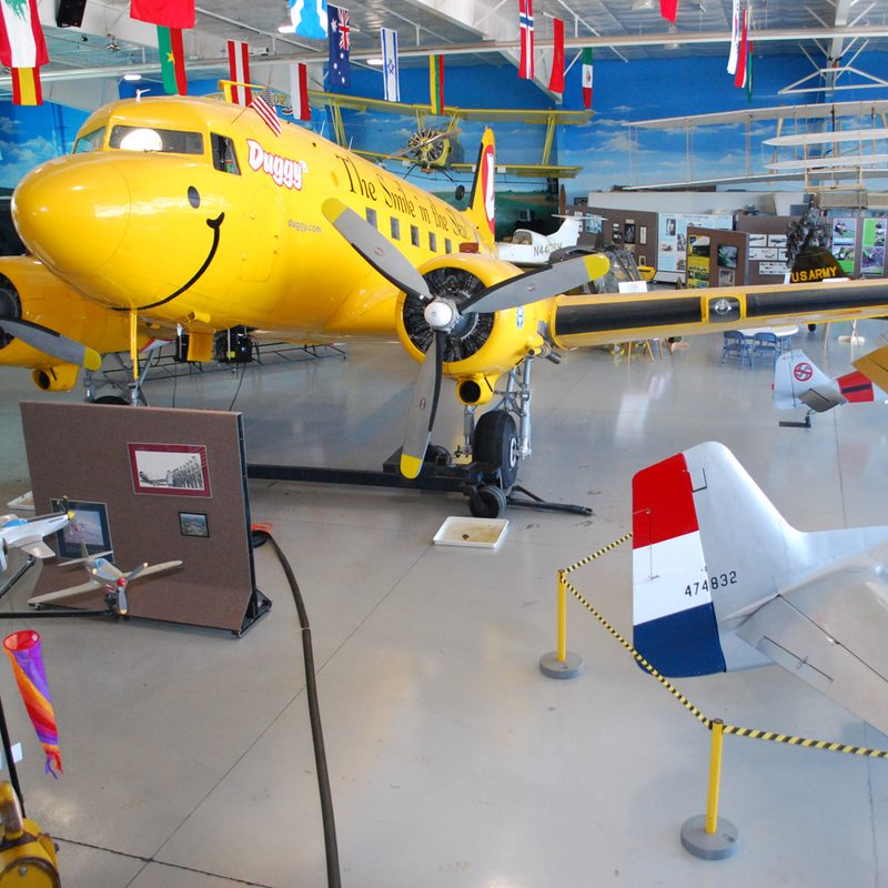 A large, yellow, twin propellor airplane, inside the Fargo Air museum.