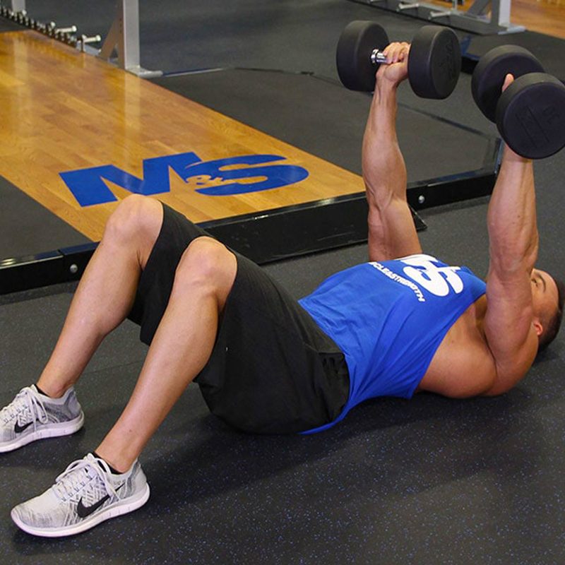 Man in gym doing a floor press