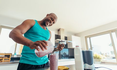 Man preparing a breakfast smoothie in the kitchen