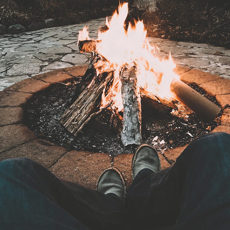 Man by burning fire In a pit
