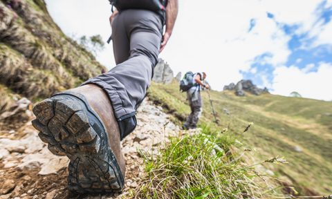 Low-angle close-up of man walking in hiking boots on the trail
