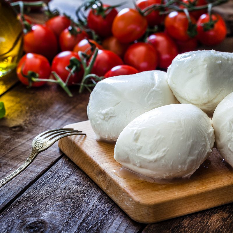Mozzarella cheese next to some tomatoes