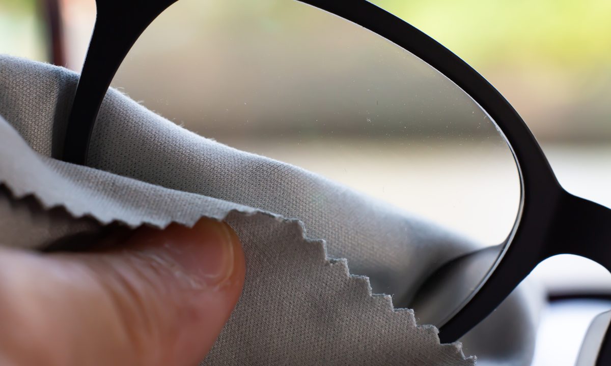 man cleaning glasses with a cloth.