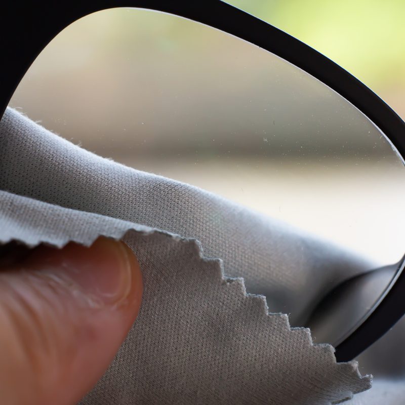 man cleaning glasses with a cloth.