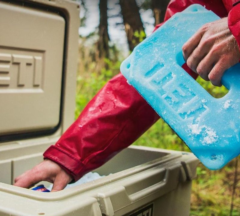 Man putting a Yeti Ice into a Yeti Cooler