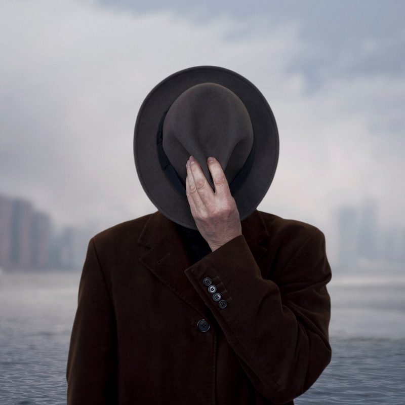 Portrait of a man with face covered by the hat.
