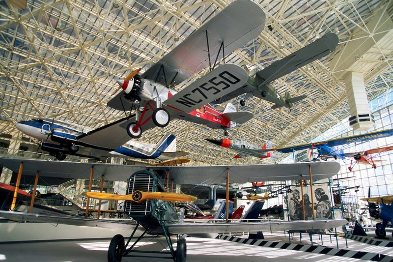 Biplanes inside an aviation museum.