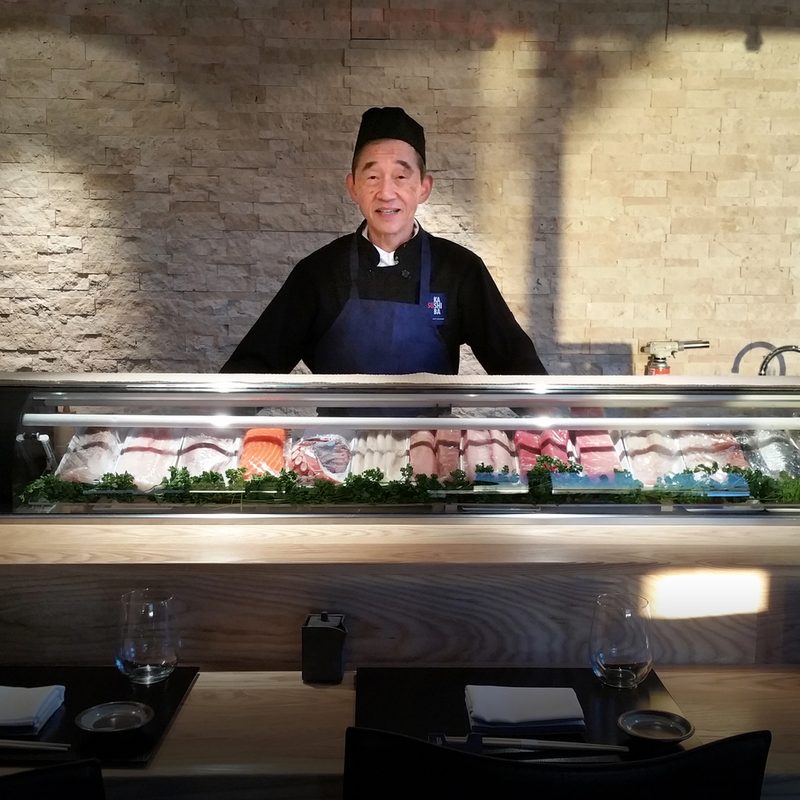 An elderly chef showing his prepared food at Sushi Kashiba.