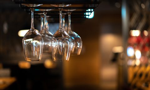 Wine glasses on hanging rack in a bar.