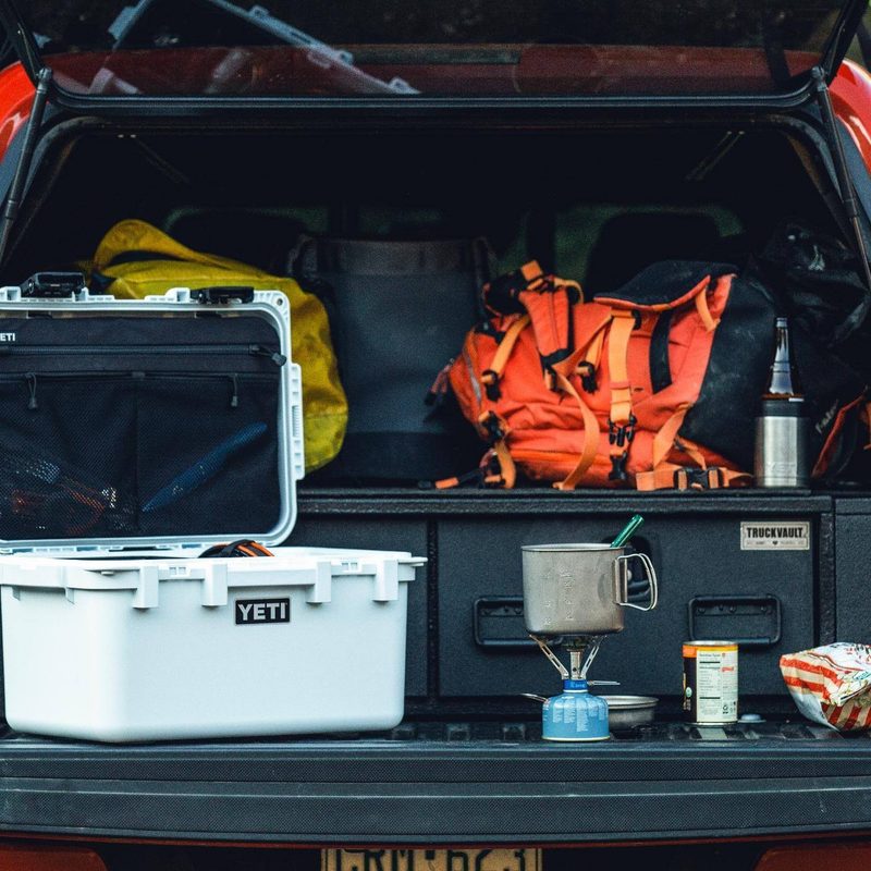 Yeti cooler in the back of a car camping set up