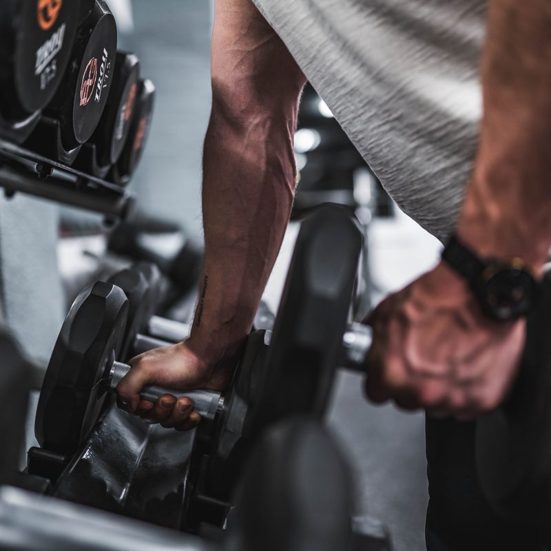 A man picking up a set of dumbbells