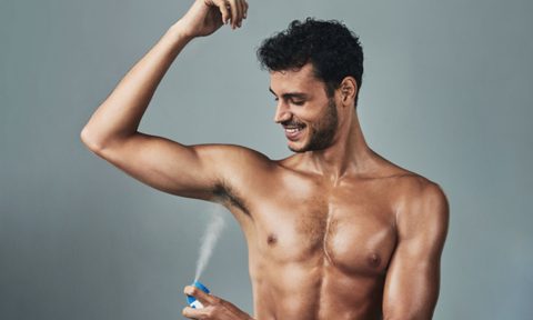 Man putting on body spray