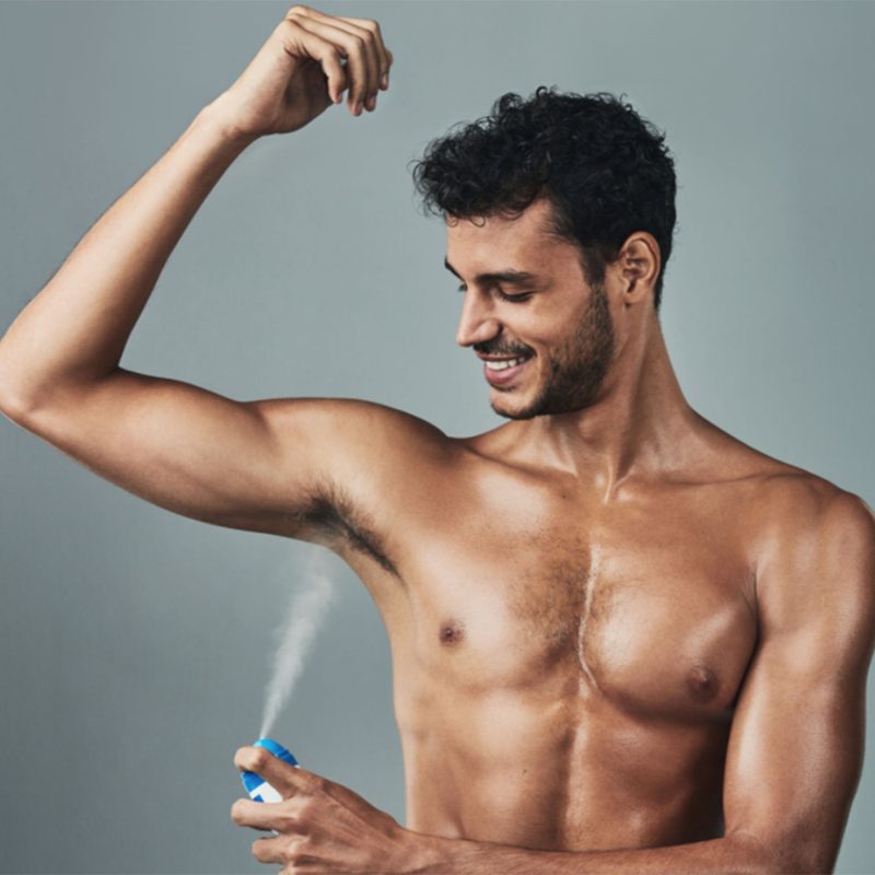 Man putting on body spray