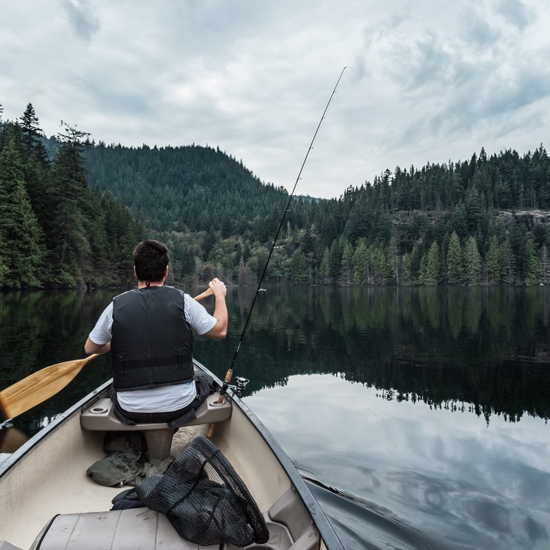 Person fishing from a canoe at Buntzen Lake in British Columbia, Canada.