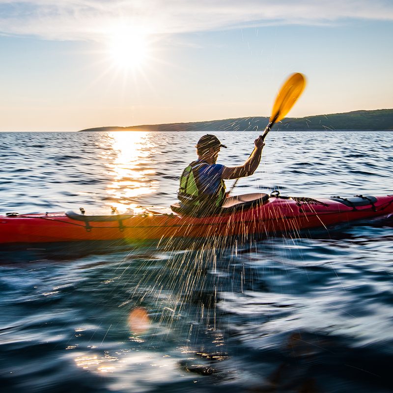 Man paddling in his kayak.