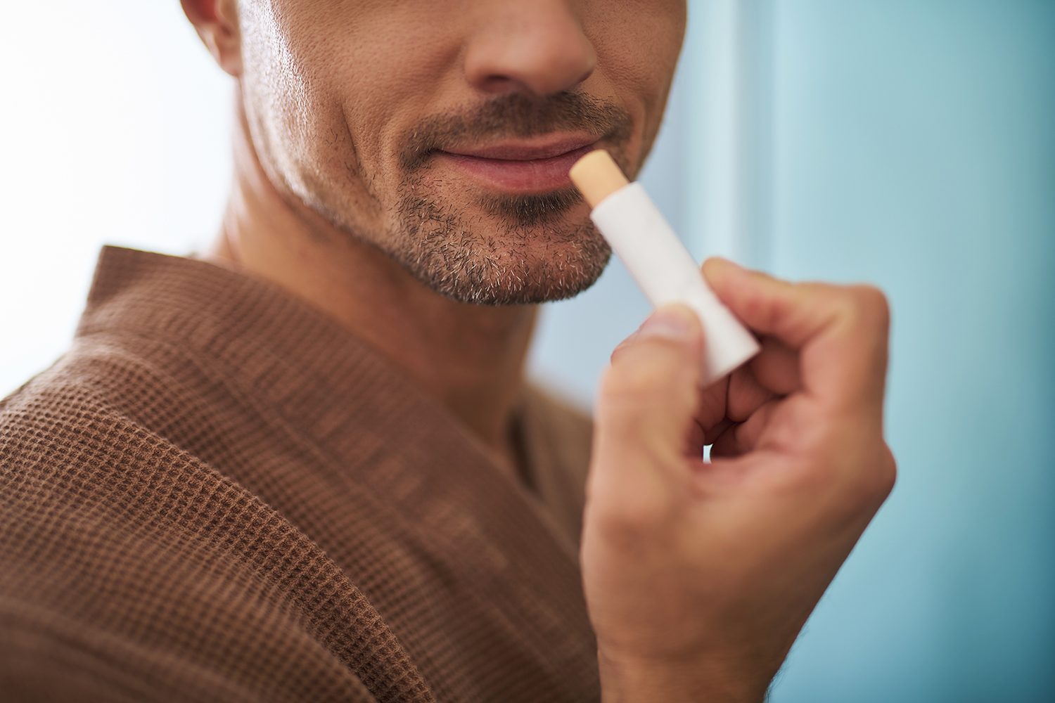 a man putting on lip balm