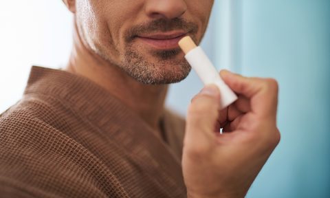 A man putting on lip balm